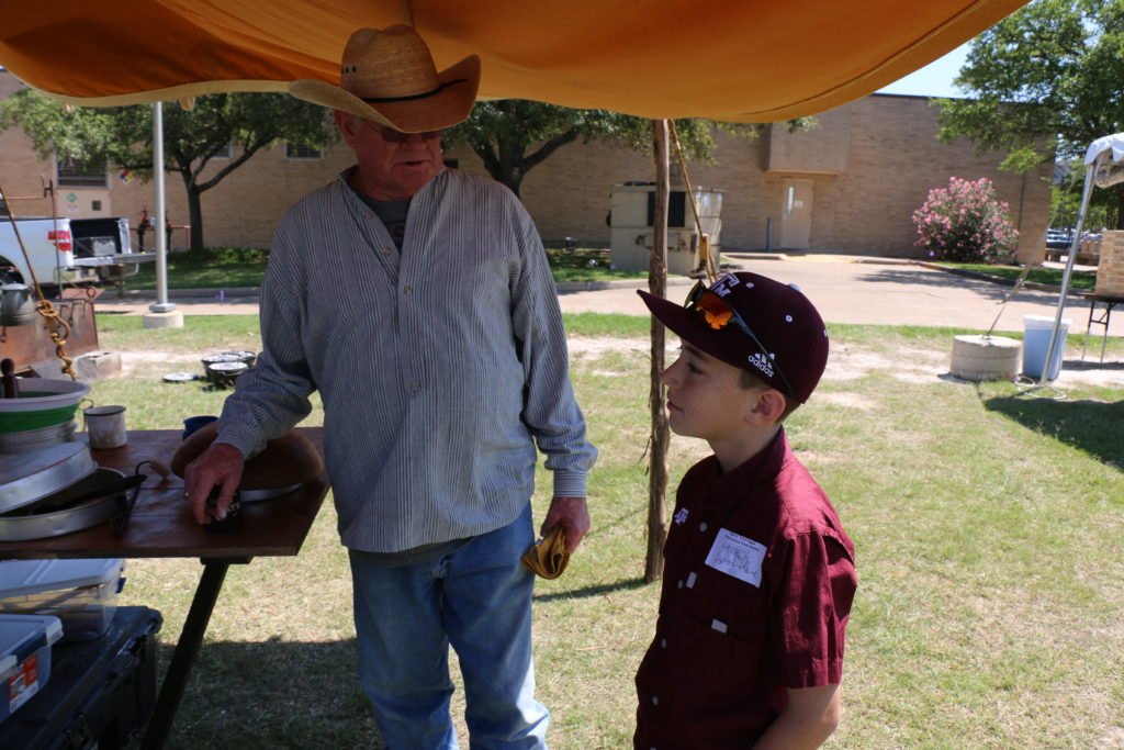 Nick Nickelson showing Jackson Larriviere chuck wagon cooking