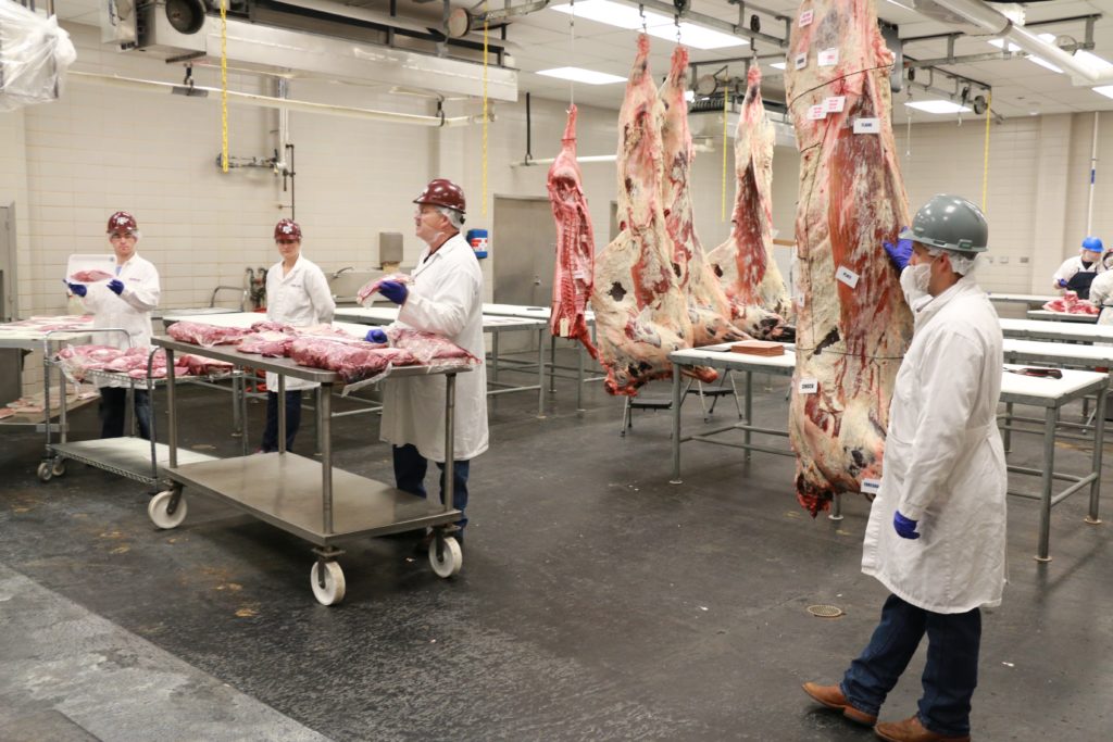 Drew Cassens, McKensie Harris, Davey Griffin, and Jason Bagley discussing the various cuts of meat