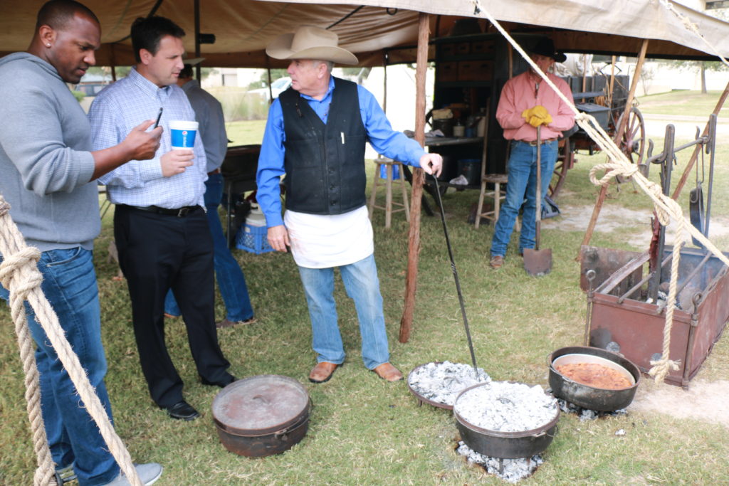 Homer Robertson (right) demonstrating Dutch oven cooking to Kirk Morrison and Clay Matvick, ESPN announcers