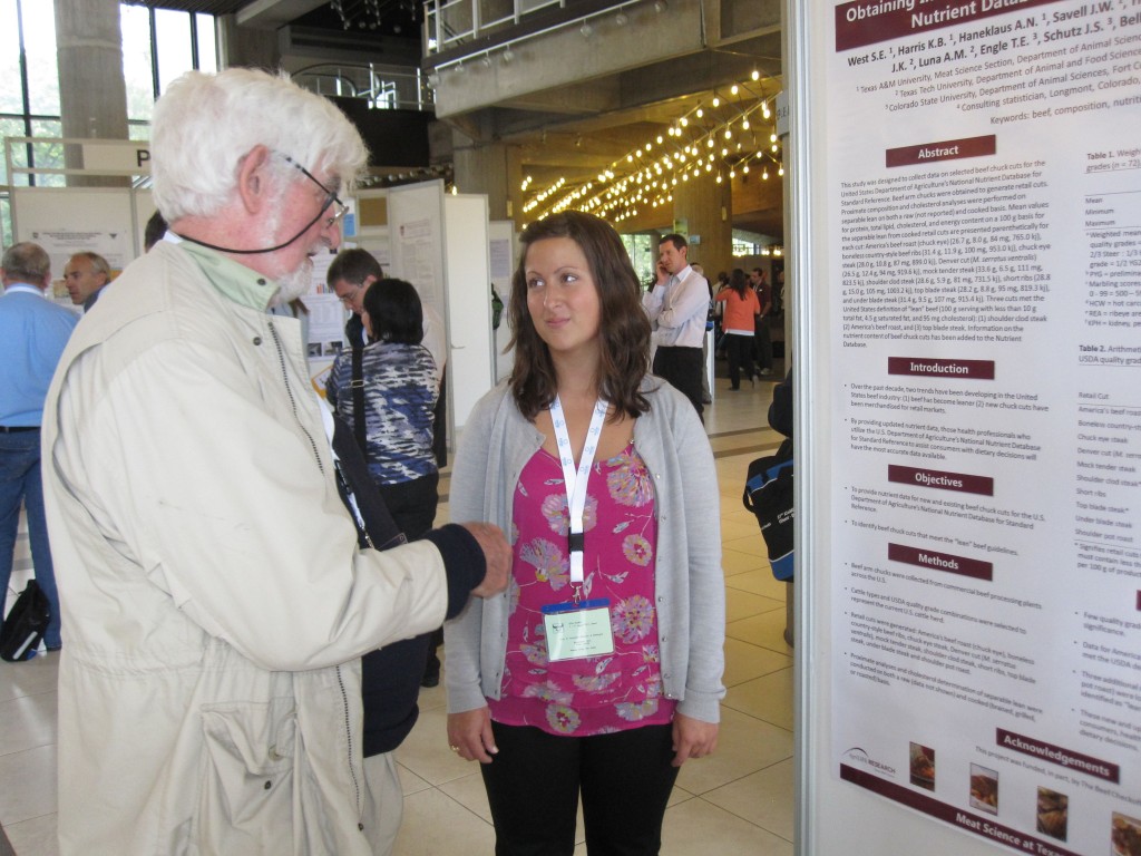 Man speaking to girl next to a board with information on it.