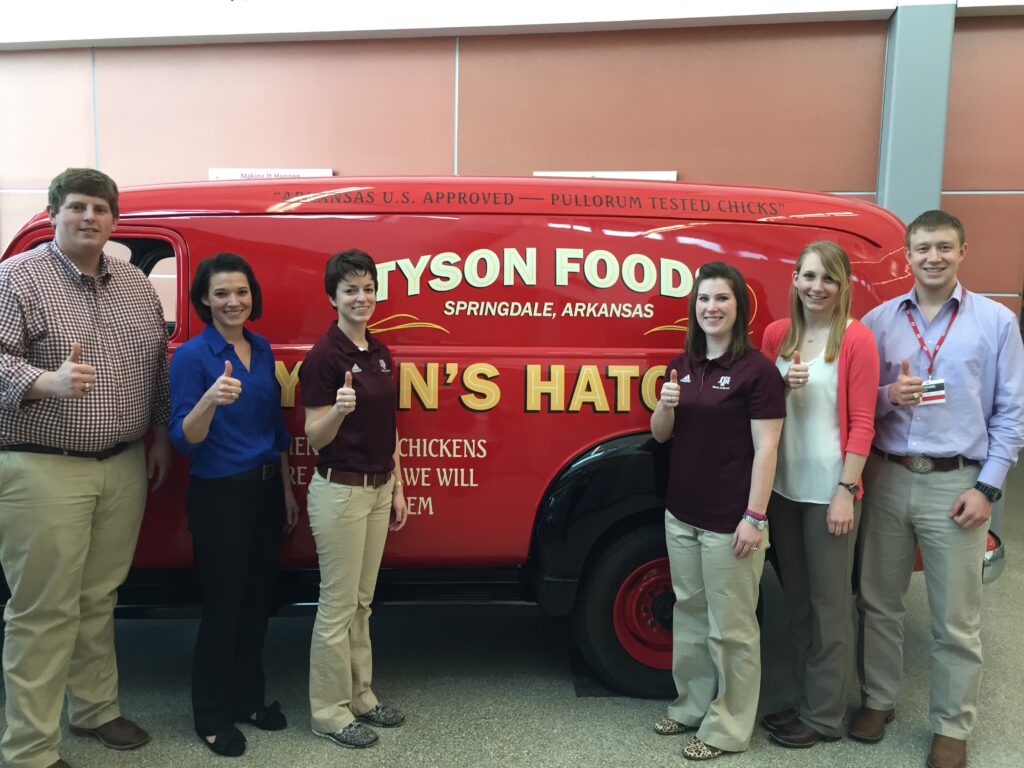 Texas A&M University Meat Science Quiz Bowl Team standing in front of a Tyson food red van. 