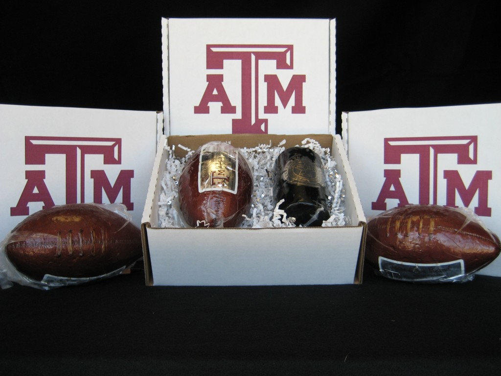 Box of the Football Cheese Pack, displayed with two footballs and three boxes with the Texas A&M University logo.