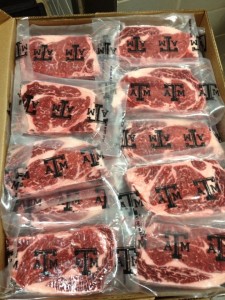 A box of packages of steaks with the Texas A&M University logo.